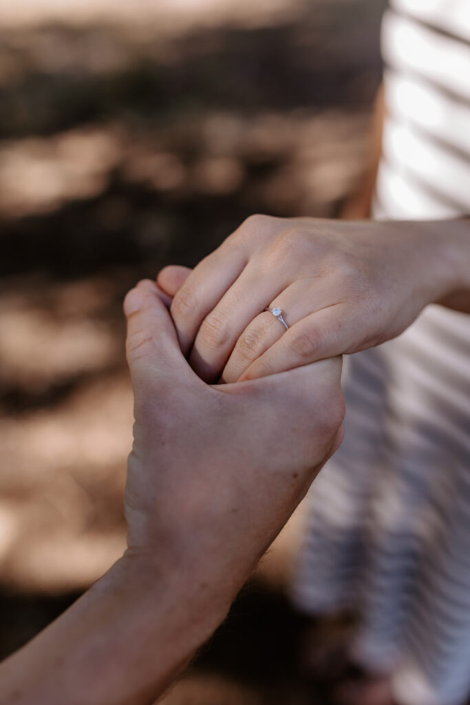 mann hält Hand der Frau und zeigt Ring
